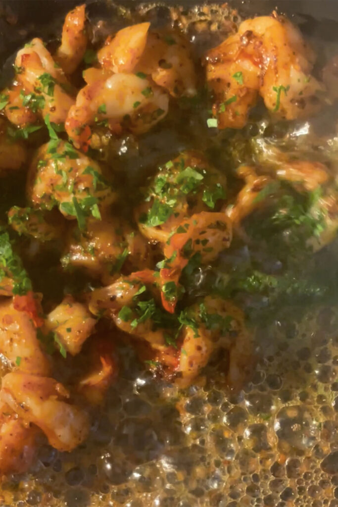 garlic butter shrimp topping with chopped parsely