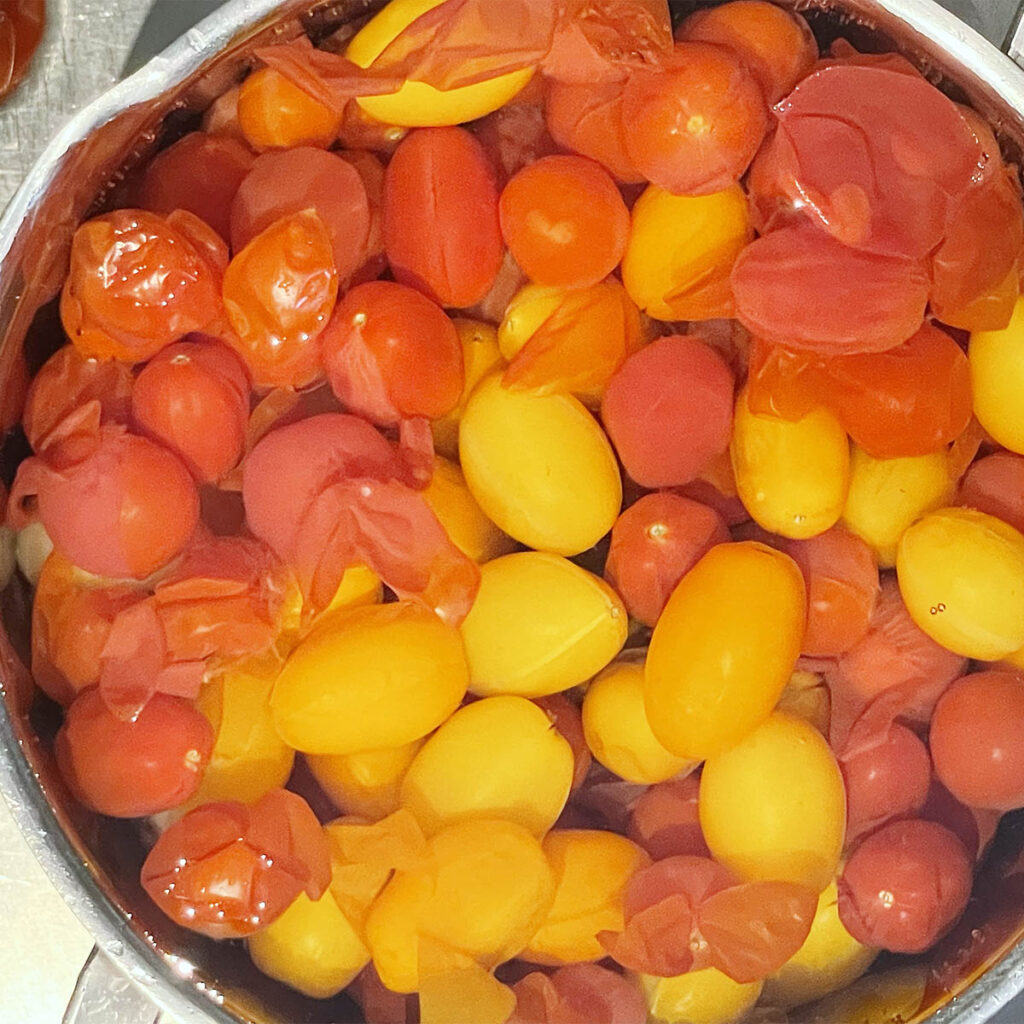 Cherry tomatoes being blanched in boiling water